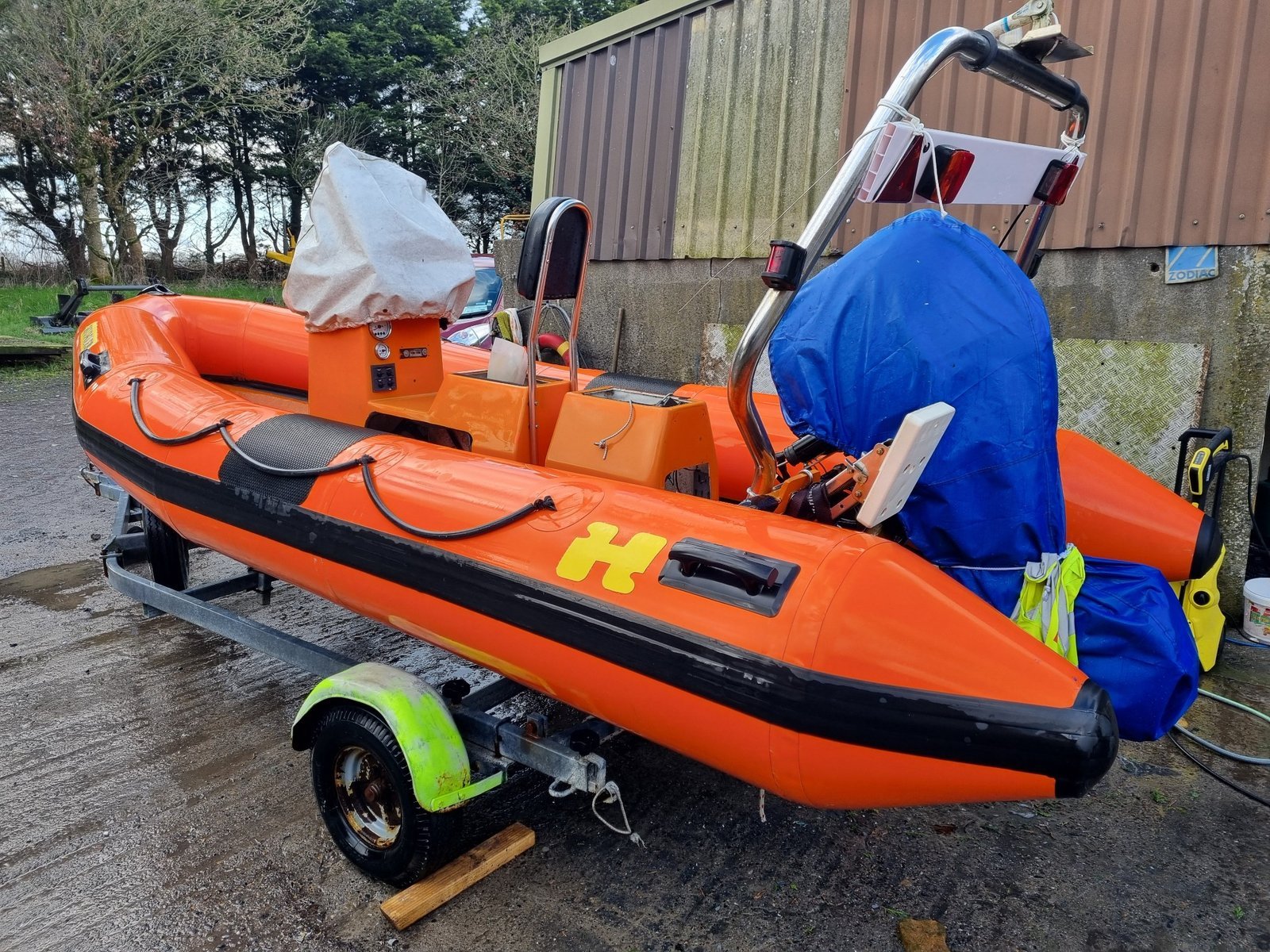 Orange RIB photographed beside the workshop